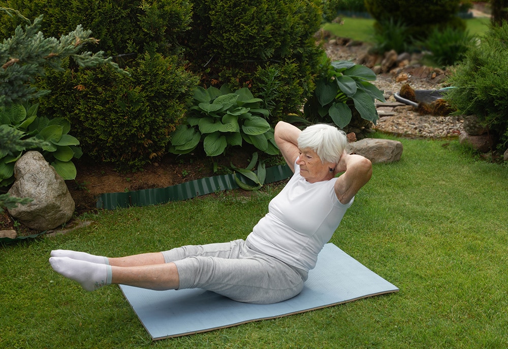 elder female doing pilates mat work